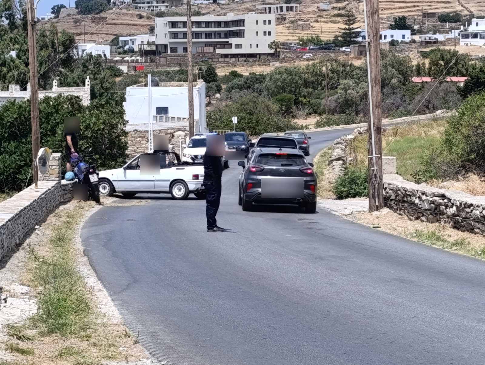 Αστυνομικός ρυθμίζει την κυκλοφορία δίπλα στα εμπλεκόμενα οχήματα.