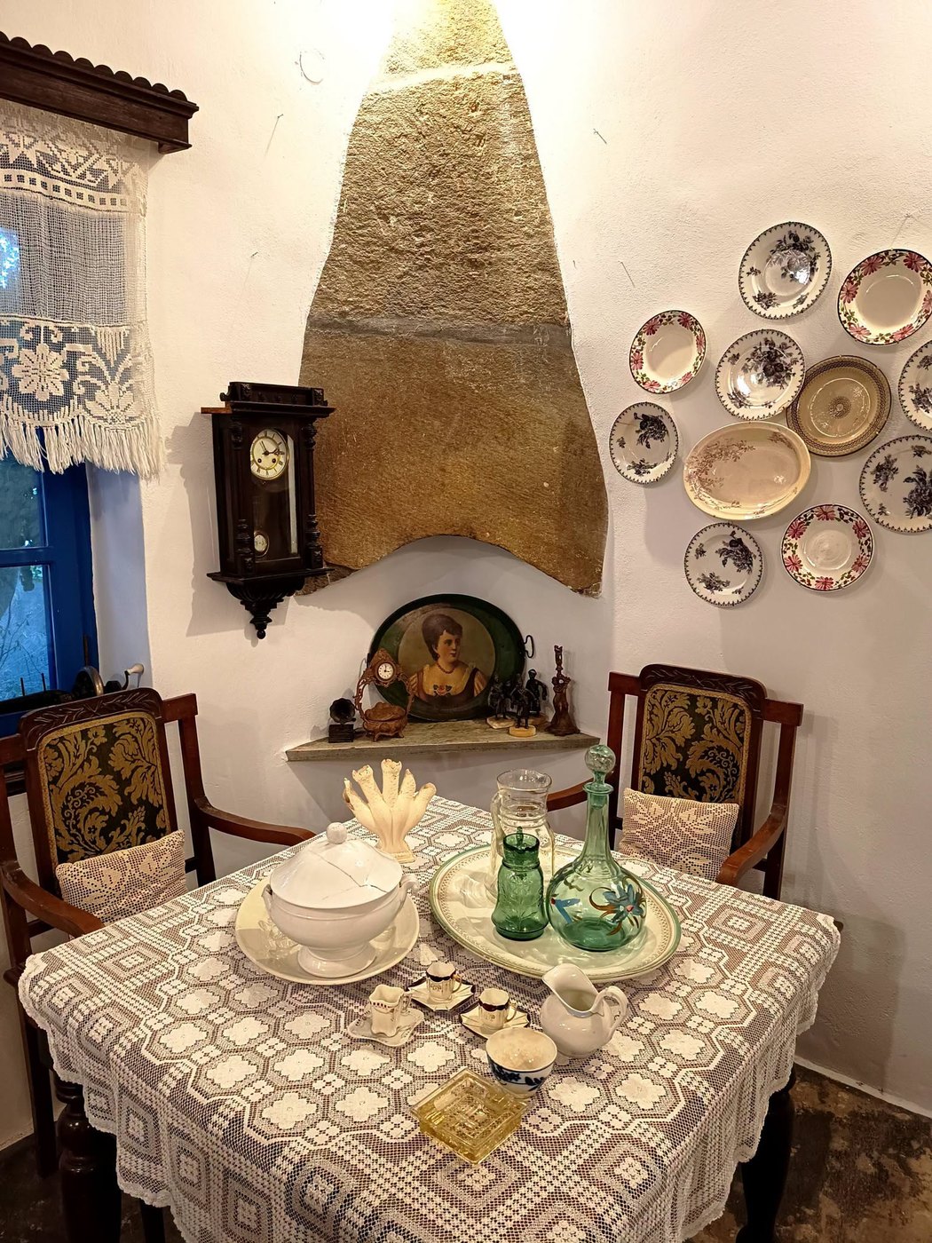 Η γωνιά με το τζάκι, το ρολόι τοίχου και τα διακοσμητικά πιάτα