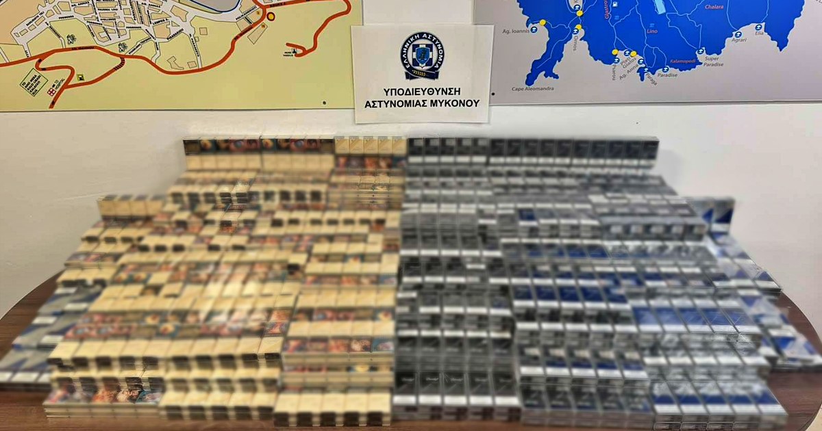 Στοίβες πακέτων τσιγάρων σε τραπέζι, κάτω από πινακίδα της Υποδιεύθυνσης Αστυνομίας Μυκόνου