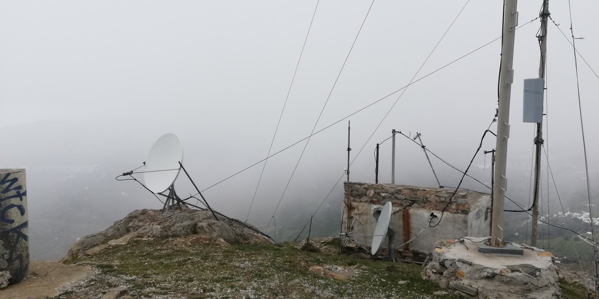 Παραβολικές κεραίες και ιστοί στην κορυφή του Εξωμβούργου μέσα στην ομίχλη