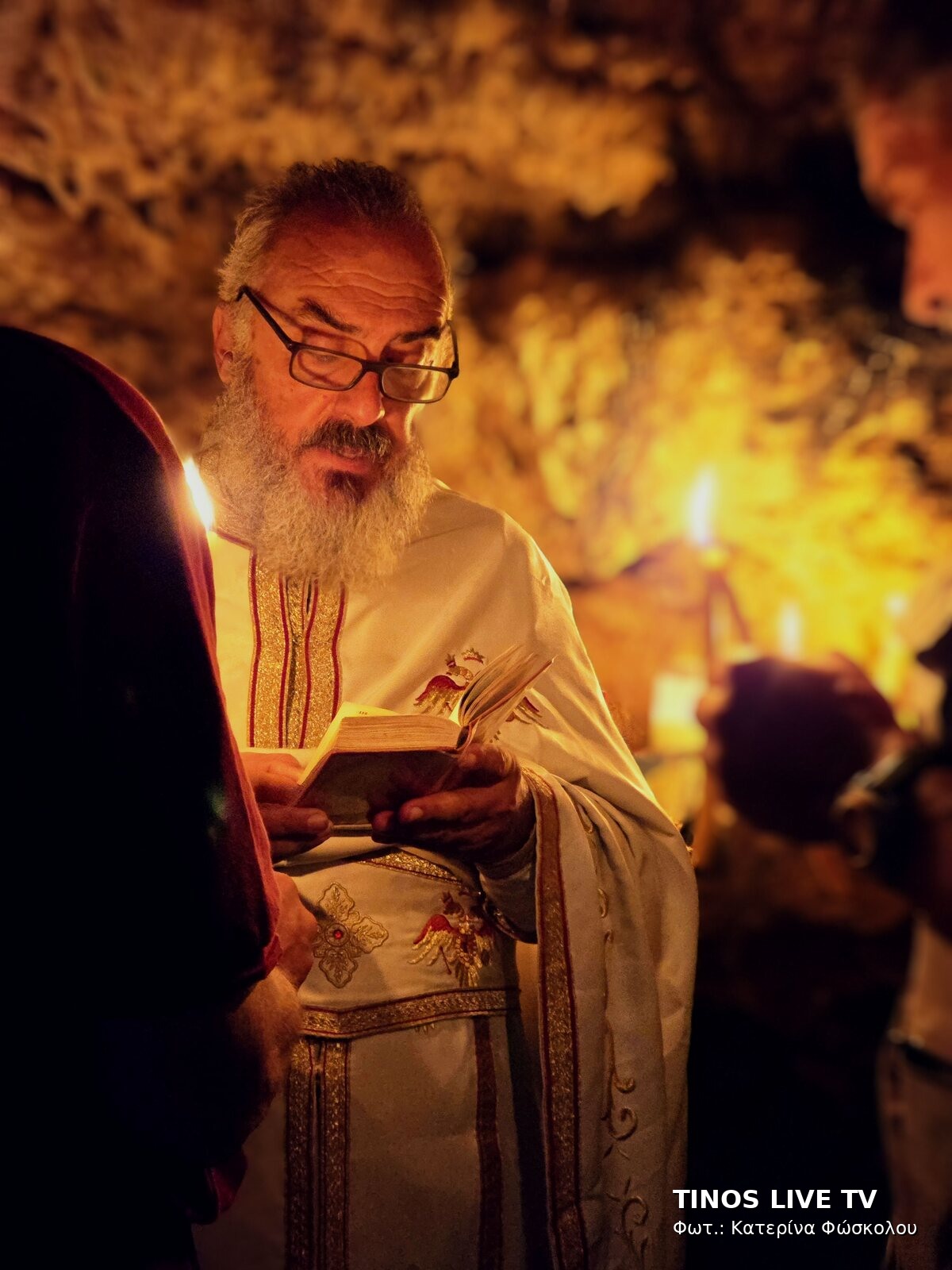 Ο π. Ευάγγελος διαβάζει υπό το φως του κεριού μέσα στη σπηλιά