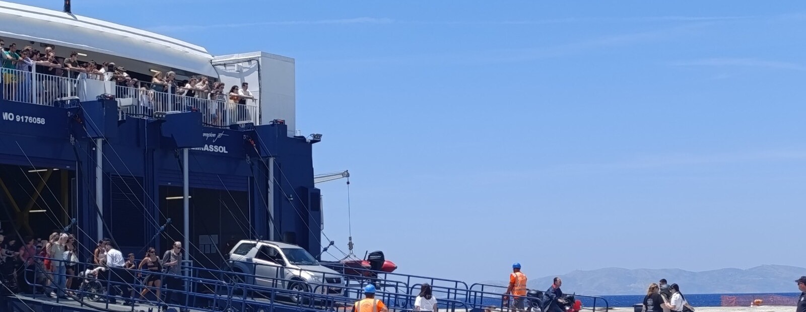 Επιβάτες κατεβαίνουν από τη ράμπα πλοίου στο λιμάνι της Τήνου