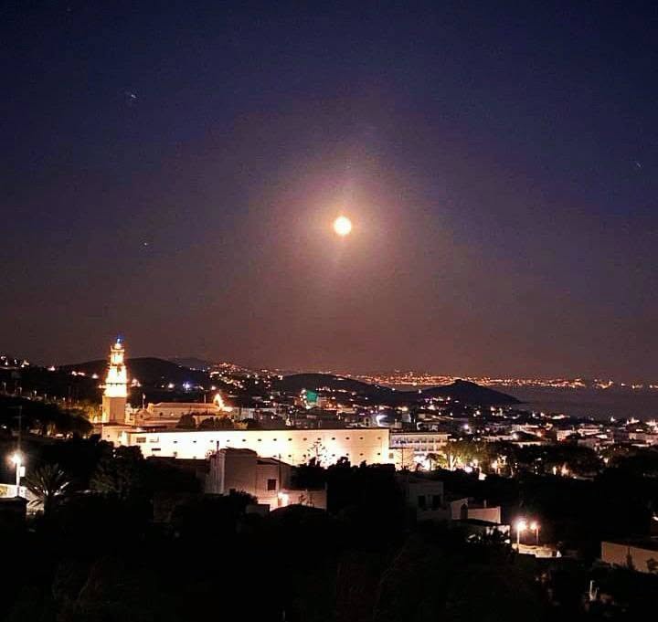 Το φεγγάρι πάνω από το καμπαναριό της Ευαγγελίστριας και τη Χώρα της Τήνου τη νύχτα