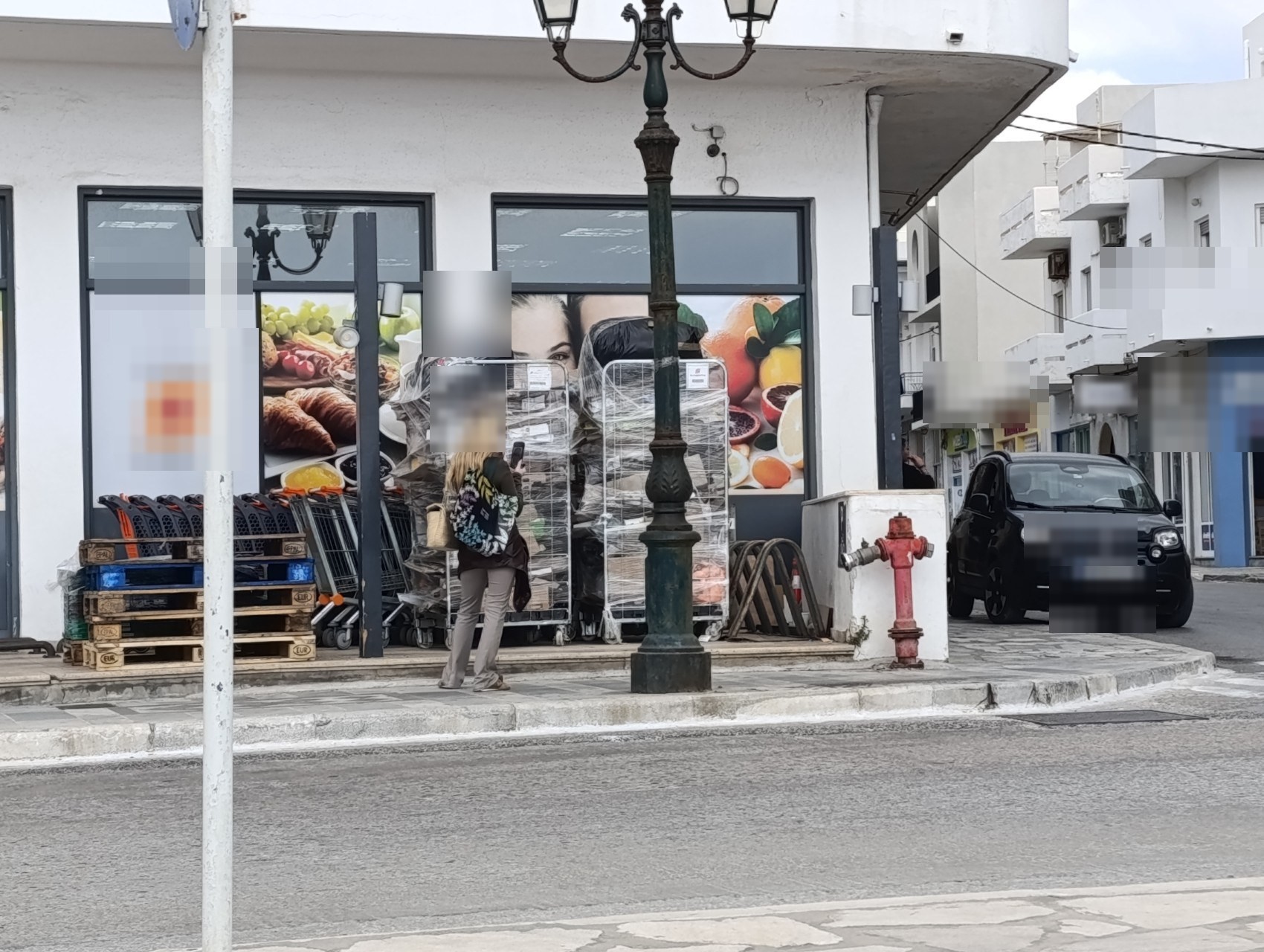 Ρόλερ-κοντέινερ με εμπορεύματα και παλέτες πάνω σε πεζοδρόμιο στη Χώρα της Τήνου