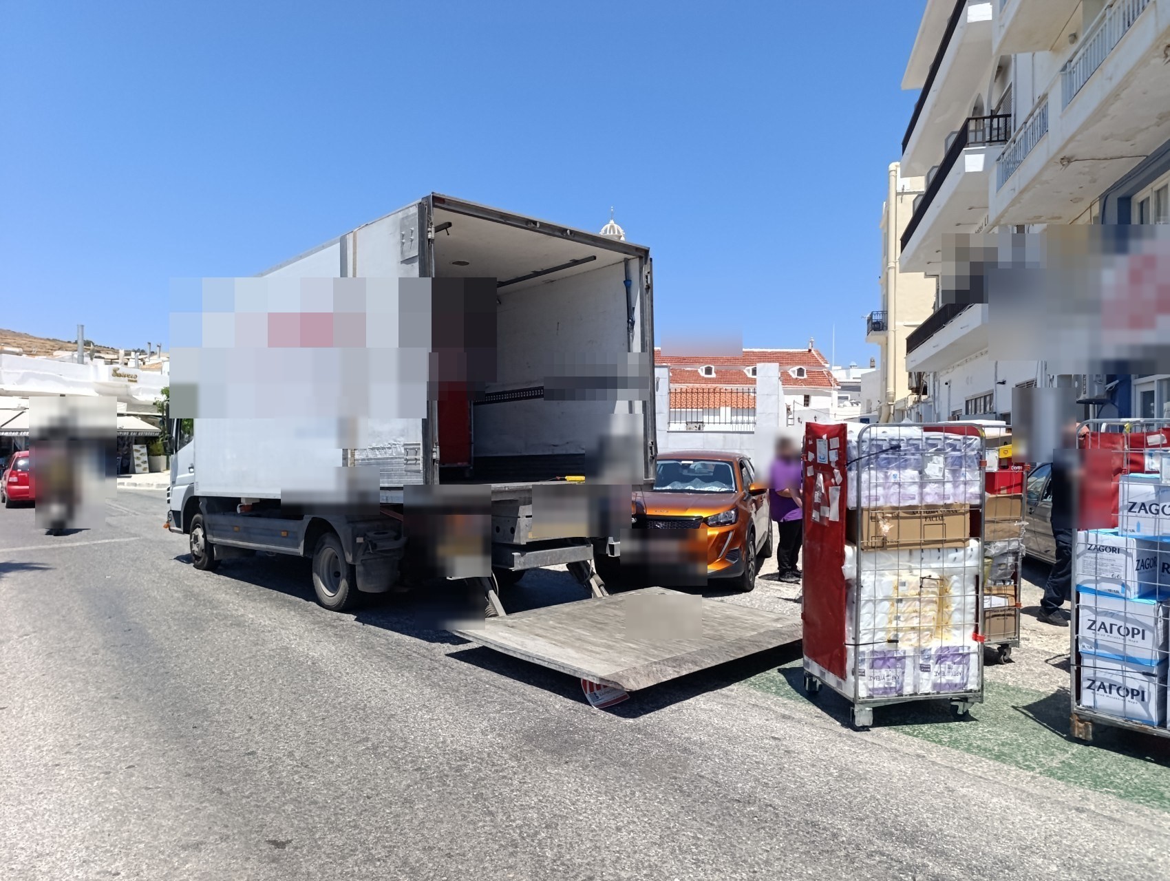 Φορτηγό με κατεβασμένη ράμπα και κλουβιά εμπορευμάτων στον δρόμο