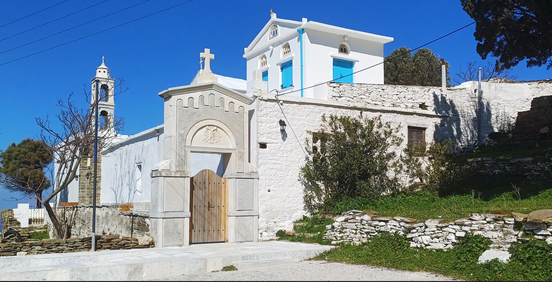 Η μαρμάρινη πύλη της Ιεράς Μονής Καταπολιανής Υστερνίων με τον δικέφαλο αετό και το καμπαναριό
