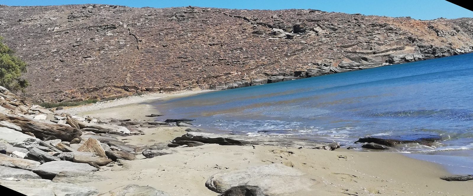 Η άμμος και τα βότσαλα της Καντάνης με τον λόφο απέναντι