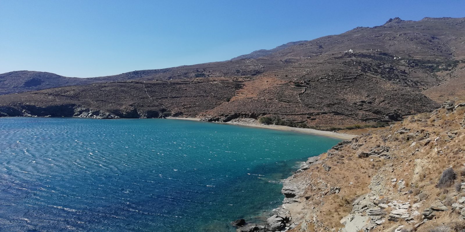 Ο κόλπος της Καντάνης με τιρκουάζ νερά και τη γυμνή πλαγιά