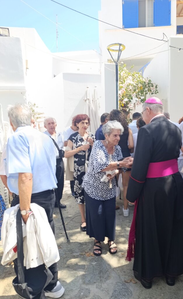 Ο Σεβασμιώτατος χαιρετά ηλικιωμένη πιστή στο κέρασμα της πανήγυρης του Αγίου Ιωάννη στην Κώμη Τήνου