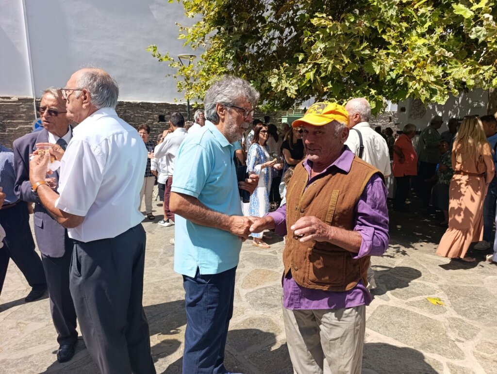 Πιστοί απολαμβάνουν το κέρασμα στην πλατεία της Κώμης Τήνου μετά τη Θεία Λειτουργία