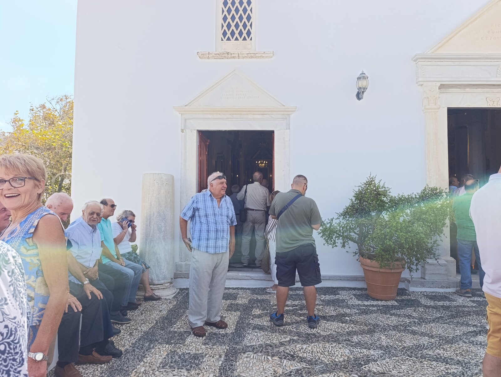 Πιστοί έξω από την εκκλησία της Κώμης Τήνου κατά τη Θεία Λειτουργία της 29ης Αυγούστου