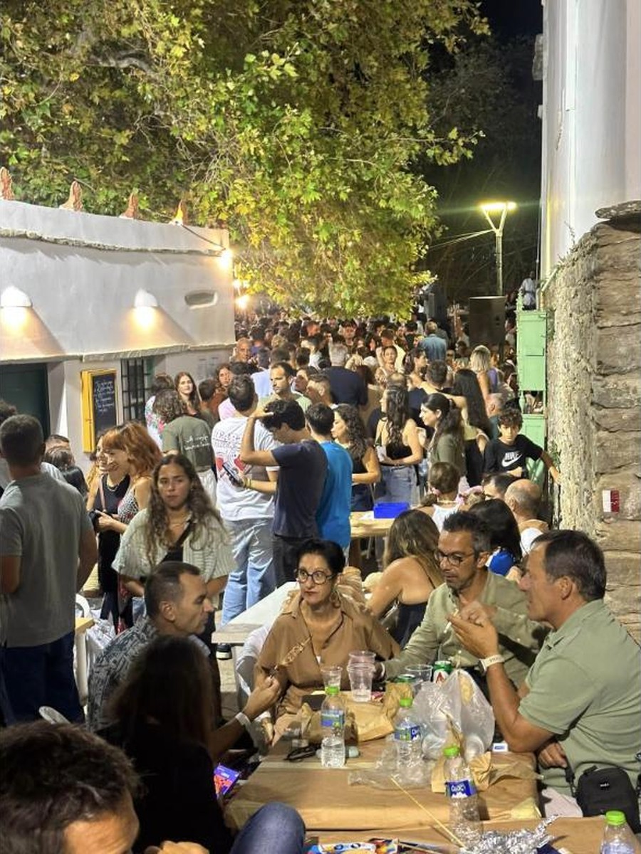 Κατάμεστα τραπέζια και κόσμος στο δρομάκι της Κώμης κάτω από τον πλάτανο