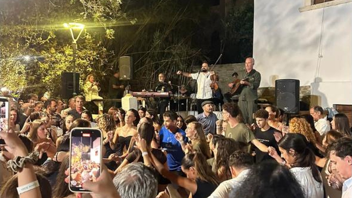 Πλήθος κόσμου χορεύει μπροστά στους μουσικούς στο πανηγύρι του Αγίου Ιωάννη στην Κώμη Τήνου
