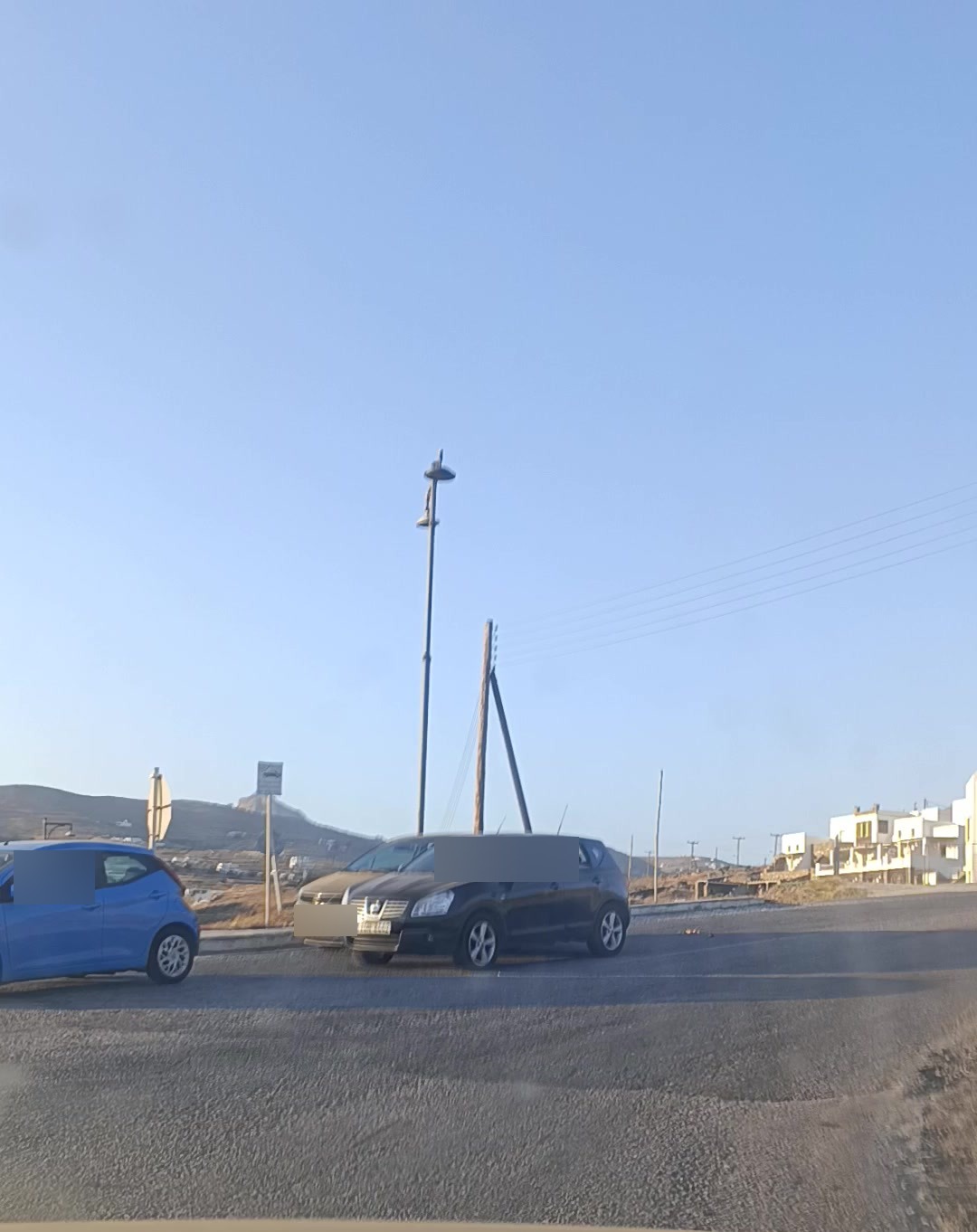 Τρία αυτοκίνητα μέσα στη διασταύρωση — δύο σταματημένα και ένα να περνάει μπροστά τους