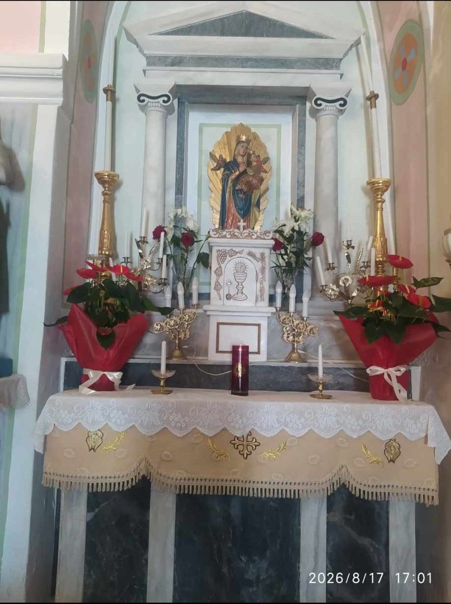 Πλάγιο ιερό του ναού με κόκκινα αλεξανδρινά και κεριά