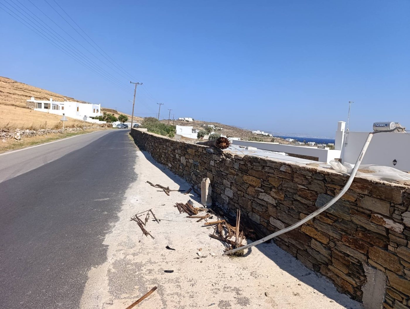 Λυγισμένος μεταλλικός σωλήνας και συντρίμμια δίπλα στην πέτρινη μάντρα στο Σμόβολο