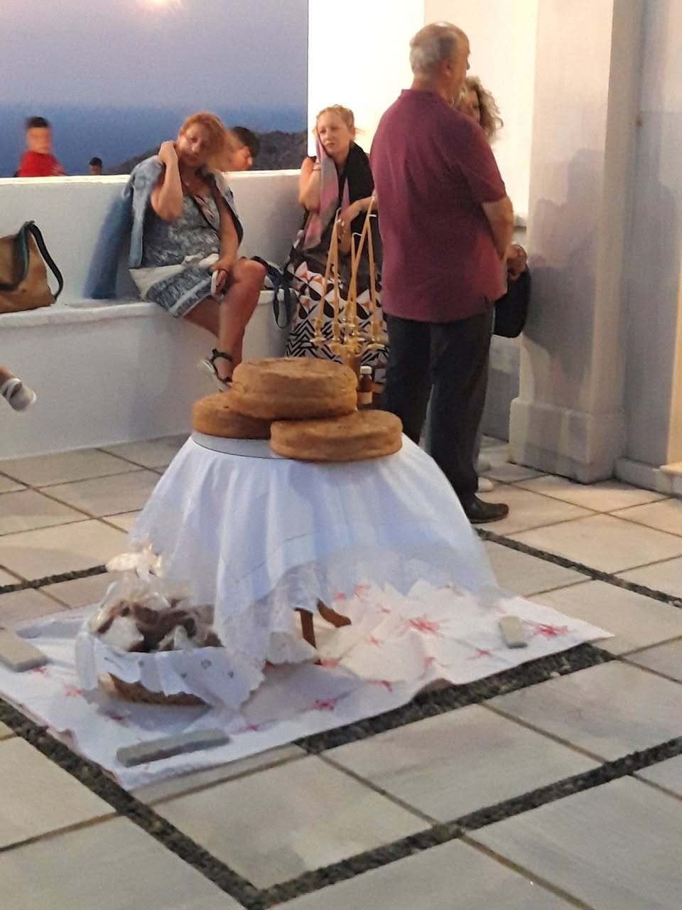 Οι άρτοι της αρτοκλασίας στο προαύλιο του ναού, με τη θάλασσα στο βάθος