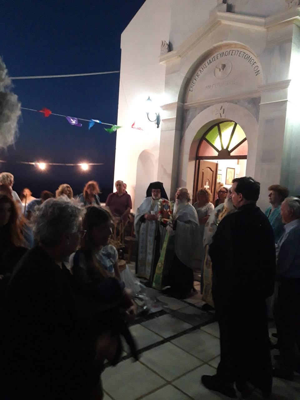 Ιερείς και πιστοί έξω από τον ναό στον Μαμάδο κατά τον εσπερινό