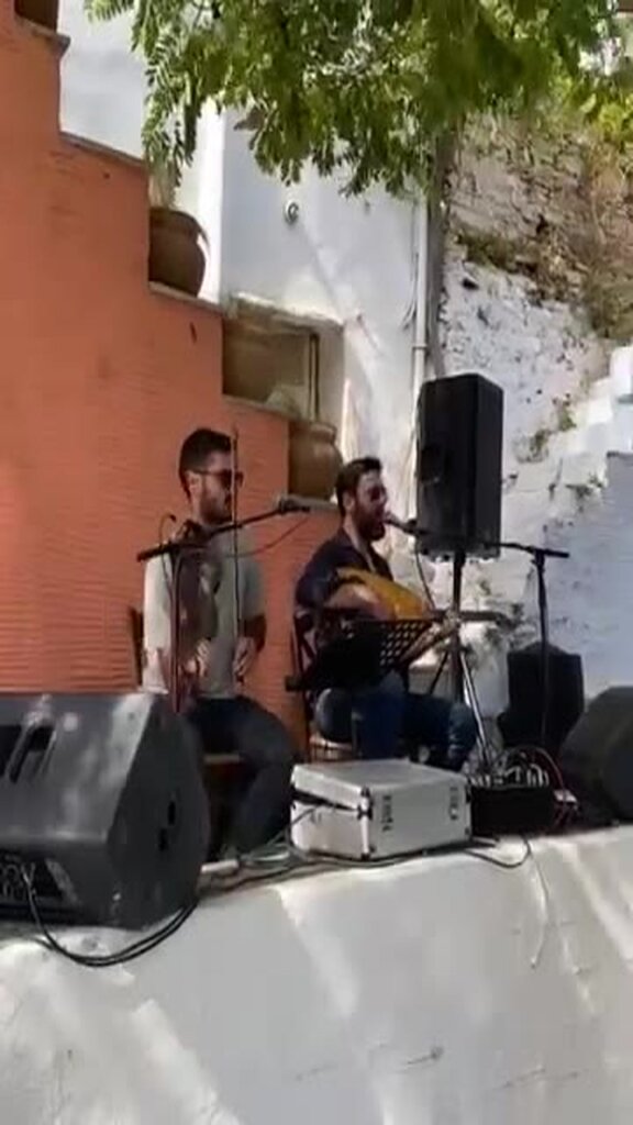 Δύο οργανοπαίκτες, βιολί και λαούτο, στο γλέντι του Αρνάδου Τήνου