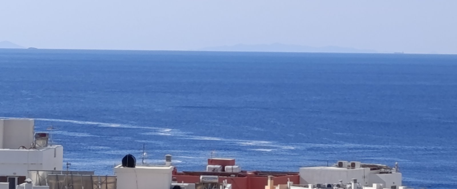 Λωρίδες αφρού στη θάλασσα μπροστά στη Χώρα της Τήνου, πρωί Σαββάτου 26/9/2026