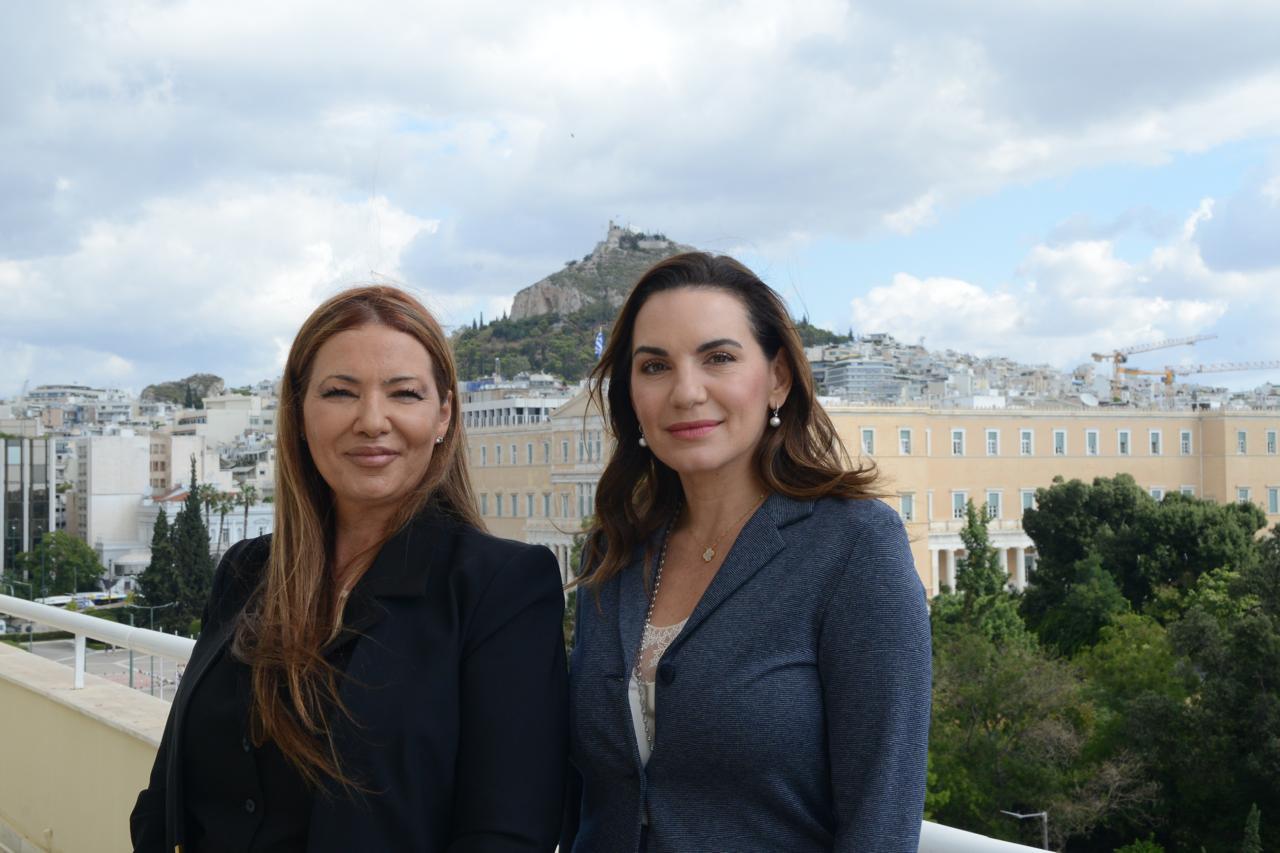 Η Υπουργός Τουρισμού Όλγα Κεφαλογιάννη και η Πρέσβειρα του Ισραήλ Pninat Yanay στο μπαλκόνι του Υπουργείου, με φόντο τη Βουλή και τον Λυκαβηττό