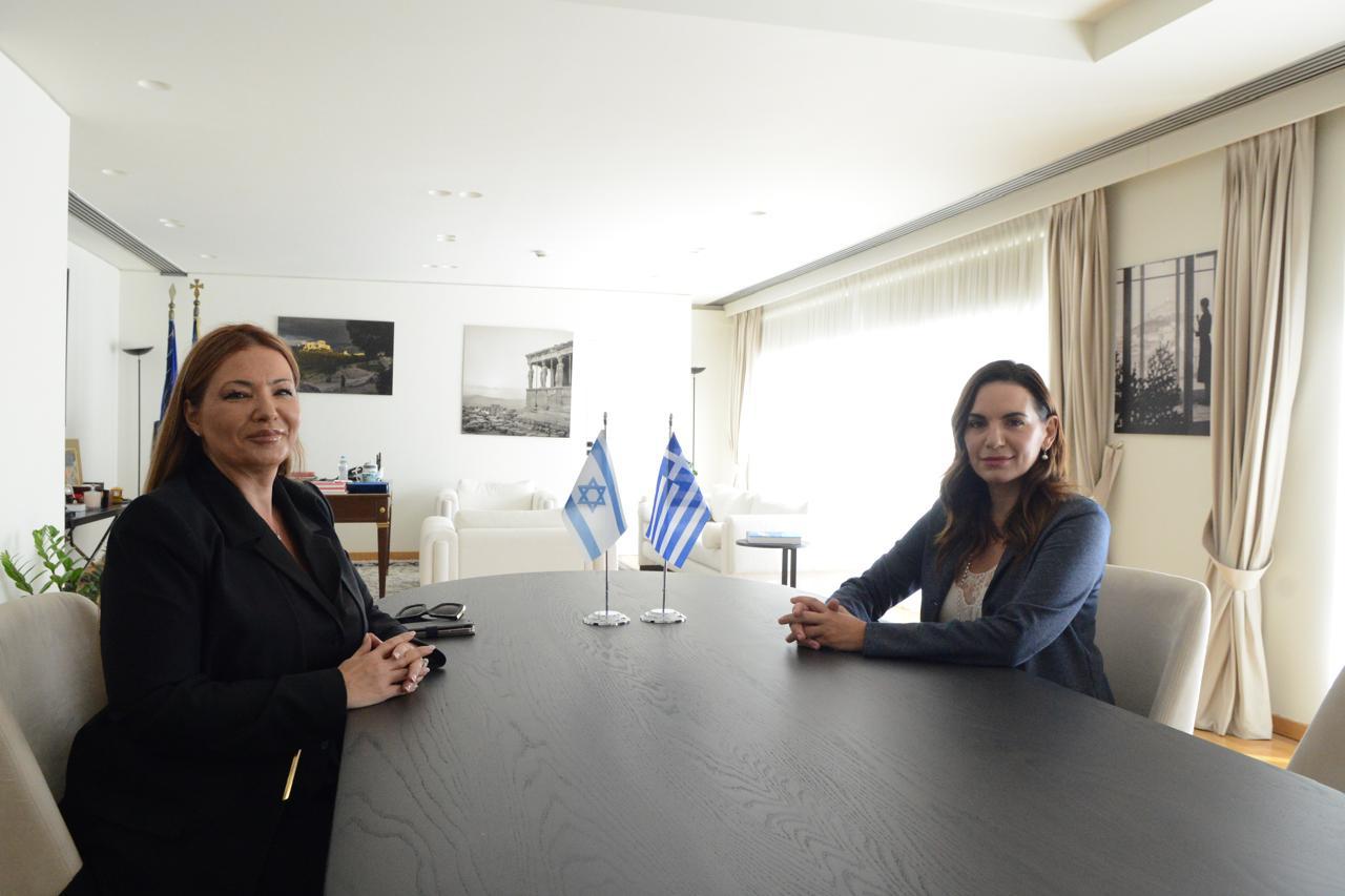 Η Όλγα Κεφαλογιάννη και η Pninat Yanay στο τραπέζι της συνάντησης, με τις σημαίες Ισραήλ και Ελλάδας