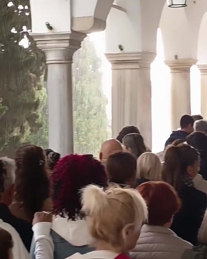 Προσκυνητές περιμένουν κάτω από τους θόλους της στοάς της Ευαγγελίστριας