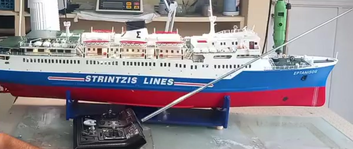 Τηλεκατευθυνόμενο μοντέλο του πλοίου Επτάνησος με τα χρώματα της Strintzis Lines πάνω σε βάση, μπροστά του το τηλεχειριστήριο