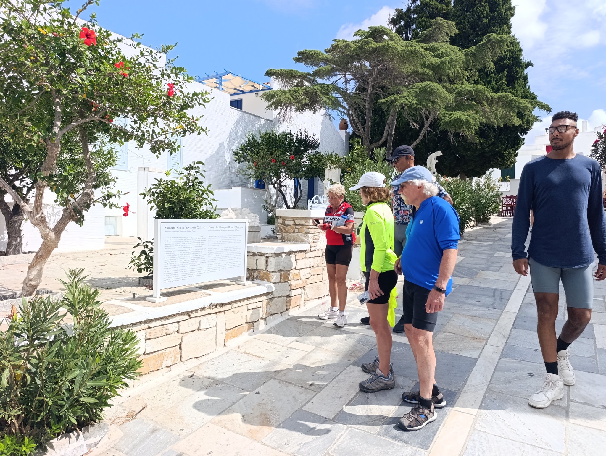 Ομάδα ποδηλατών από τις ΗΠΑ διαβάζει την πινακίδα έξω από την Οικία-Μουσείο Χαλεπά στον Πύργο