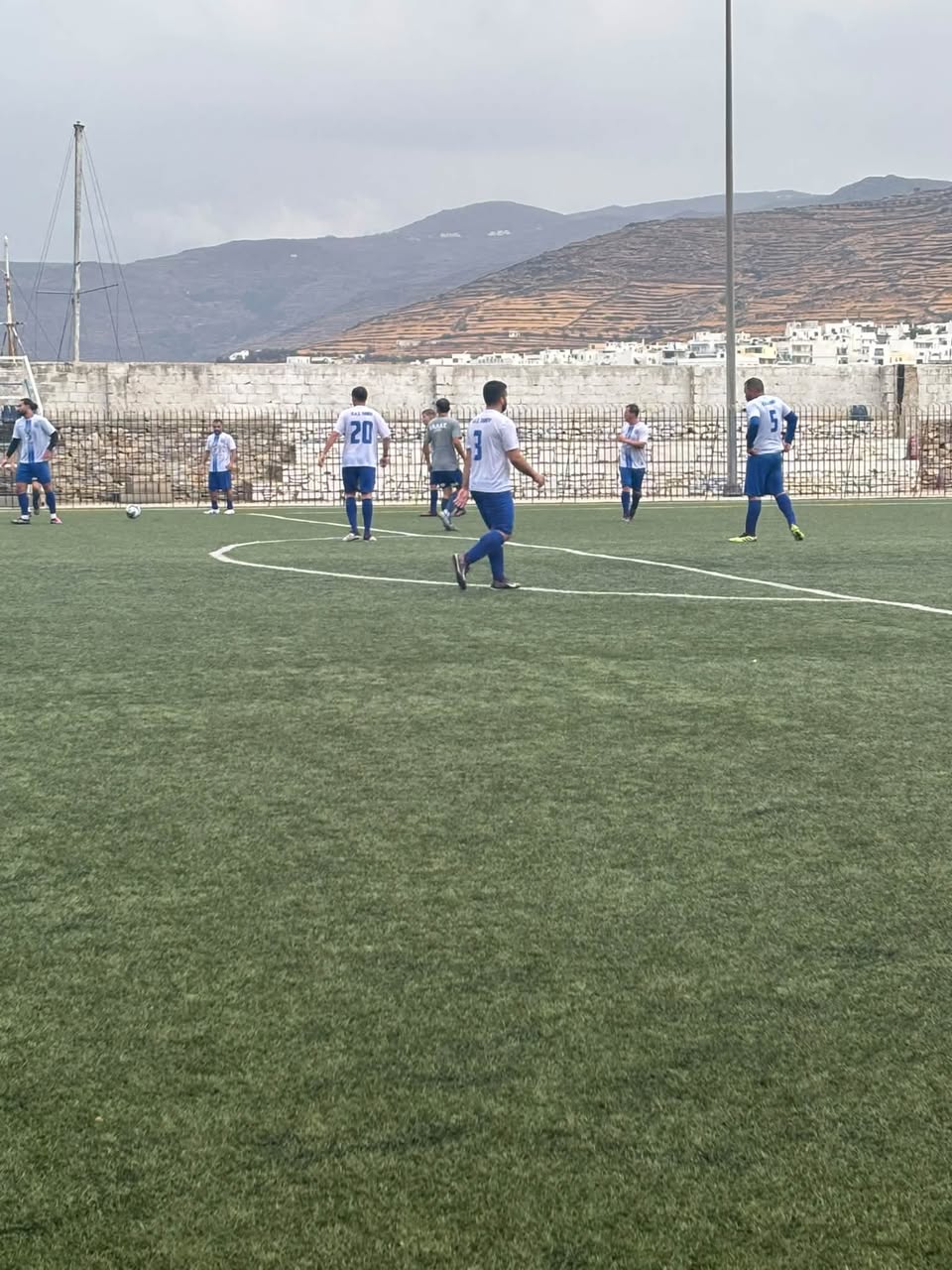 Φάση του αγώνα Π.Α.Σ. Τήνου – Ελλάς Σύρου Κ-19 με τη Χώρα στο βάθος