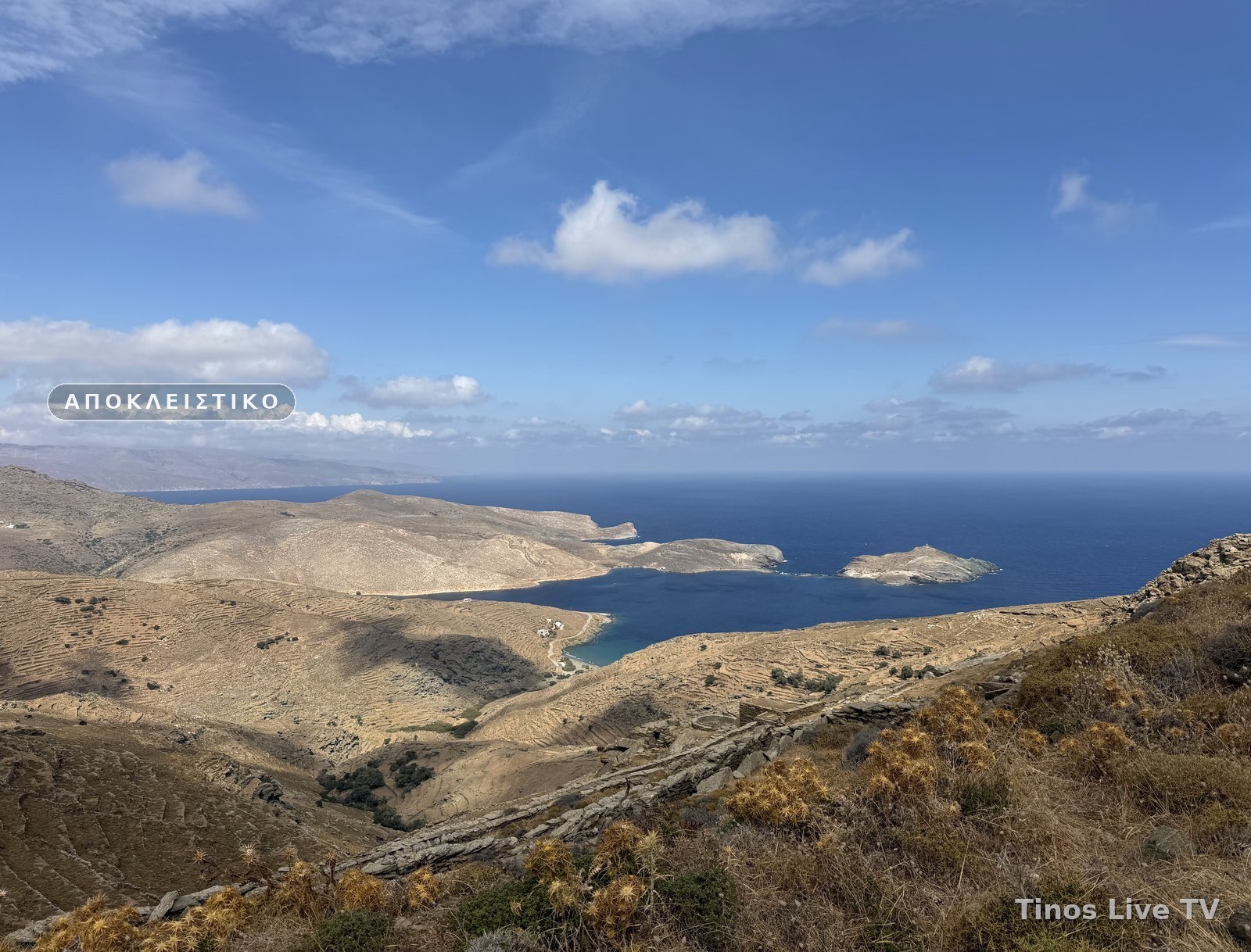 Οι πεζούλες και ο κόλπος του Πανόρμου με τη νησίδα Πλανήτη, στο βάθος η Άνδρος