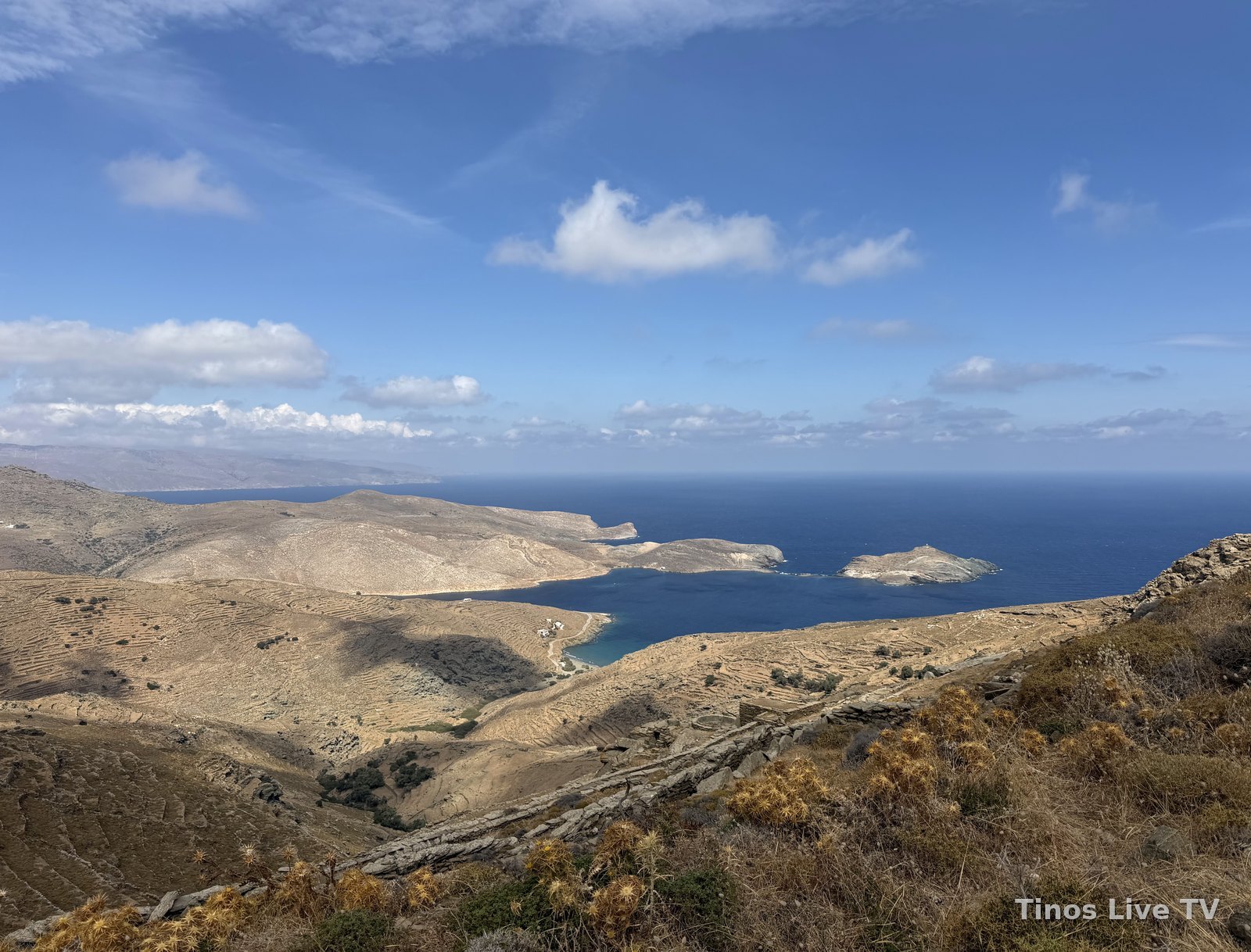 Οι πεζούλες και ο κόλπος του Πανόρμου με τη νησίδα Πλανήτη, στο βάθος η Άνδρος