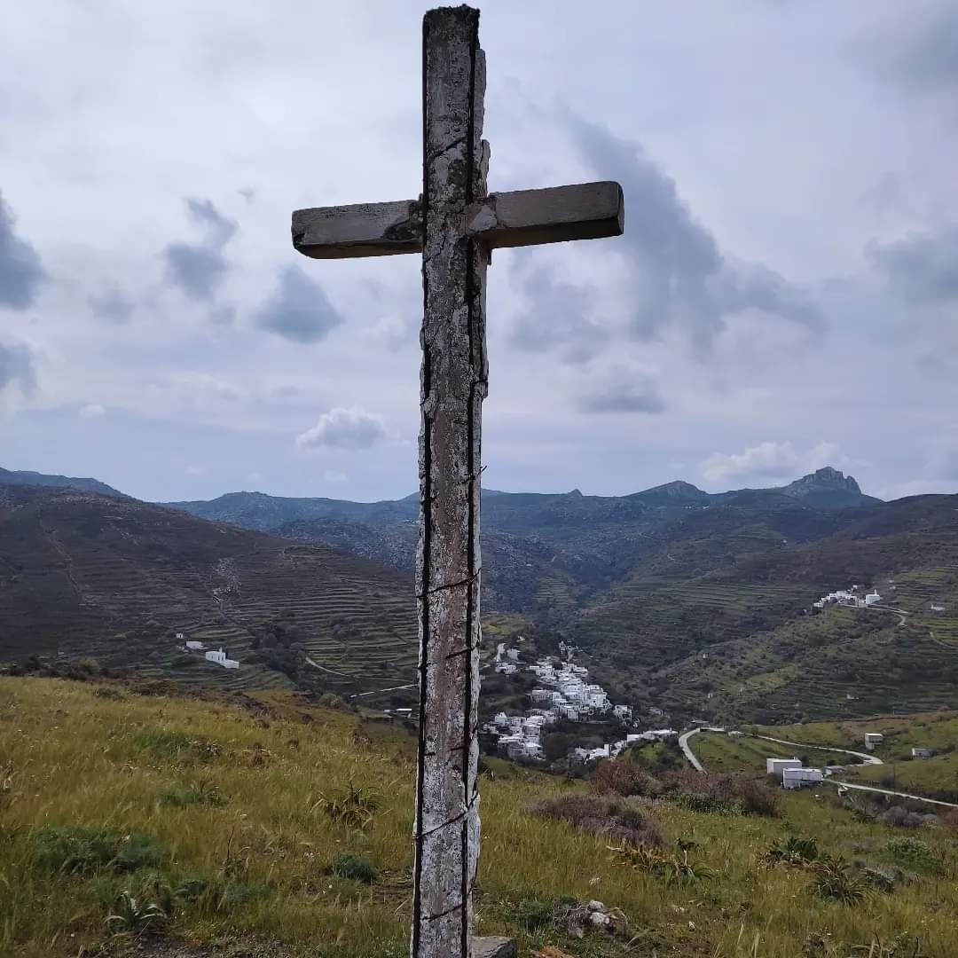 Πέτρινος σταυρός σε λόφο της Τήνου, με την Αγάπη και το Σκλαβοχώρι στο βάθος