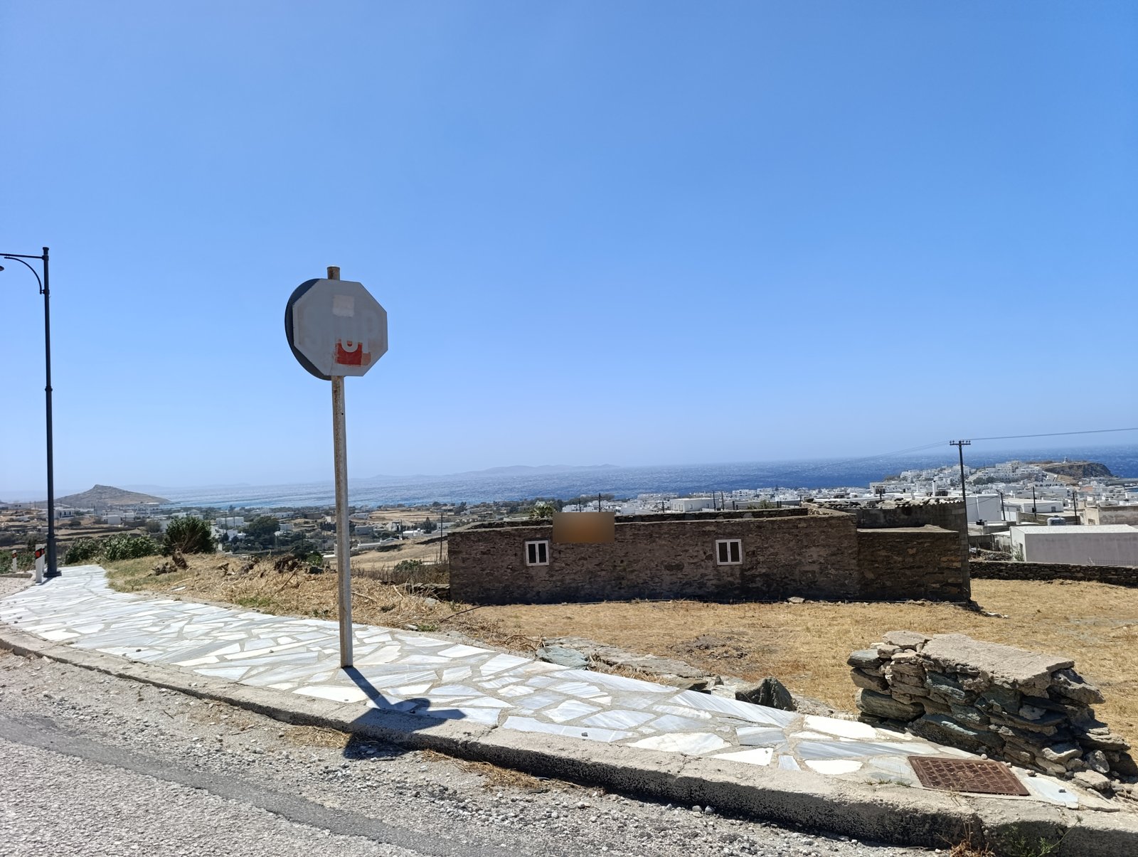 Ξεθωριασμένη πινακίδα STOP στην Περιμετρική Τήνου, 31 Ιουλίου 2026