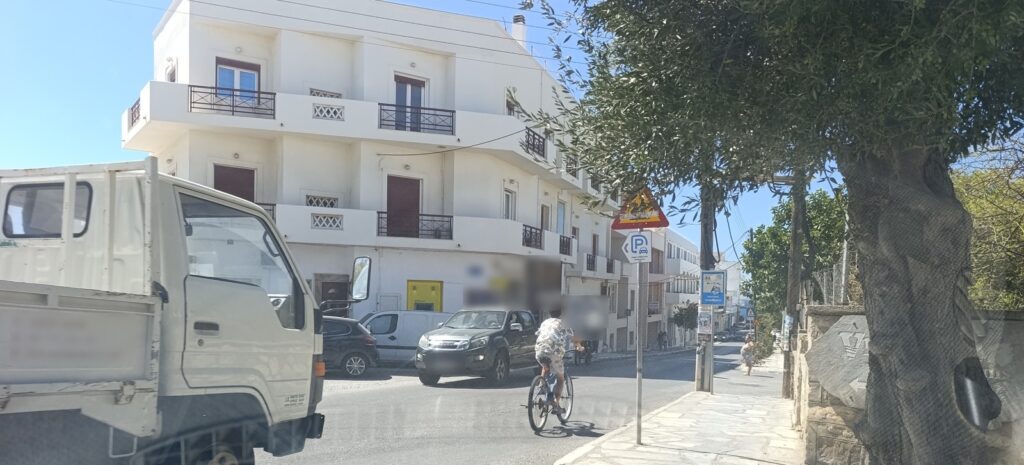 Παιδί κάνει ποδήλατο στο οδόστρωμα στη Χώρα της Τήνου, με φορτηγάκι και αυτοκίνητα γύρω του