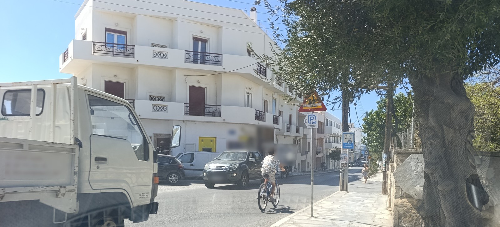 Παιδί κάνει ποδήλατο στο οδόστρωμα στη Χώρα της Τήνου, με φορτηγάκι και αυτοκίνητα γύρω του