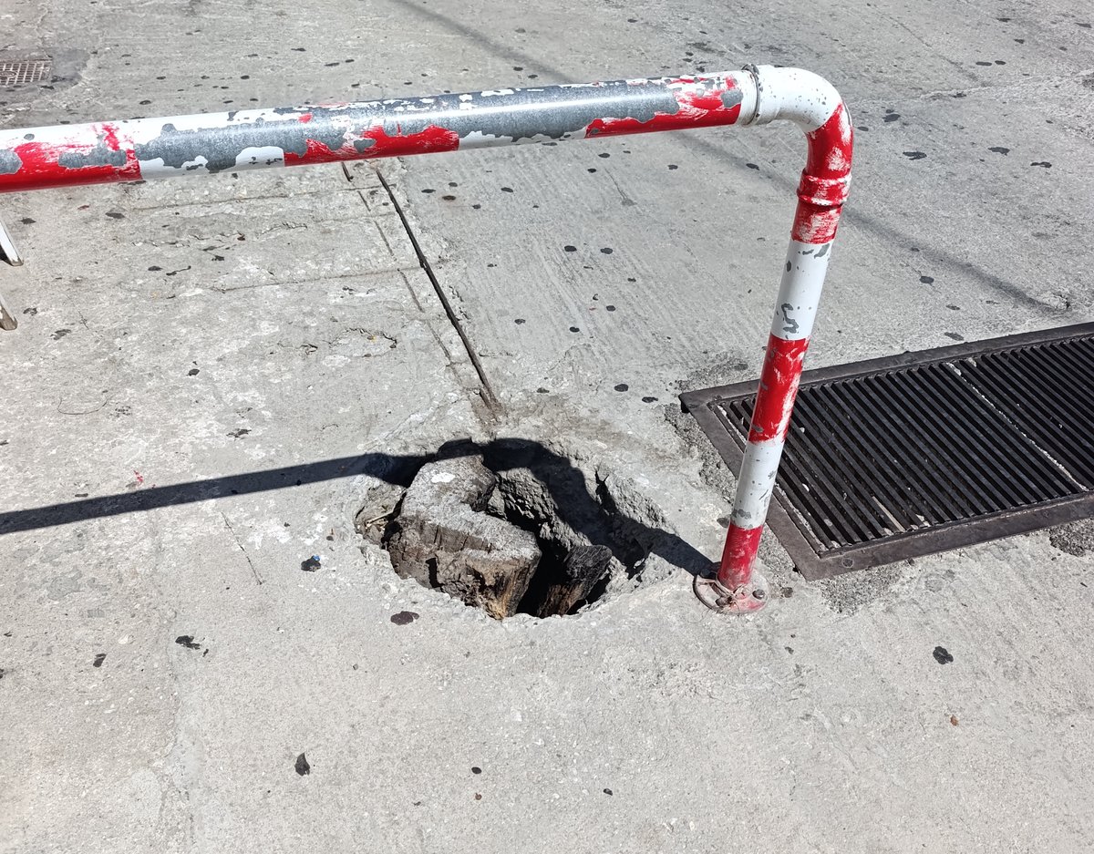 Η τρύπα στο οδόστρωμα δίπλα στο προστατευτικό κάγκελο και τη σχάρα ομβρίων