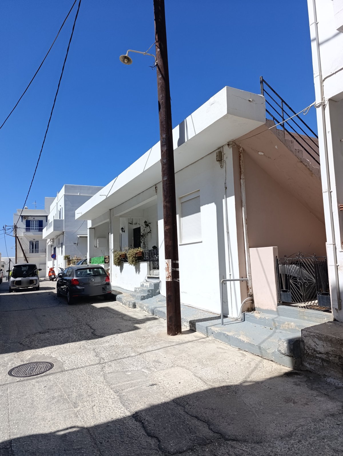Καινούργια ξύλινη κολόνα με φωτιστικό σε δρόμο της Χώρας της Τήνου