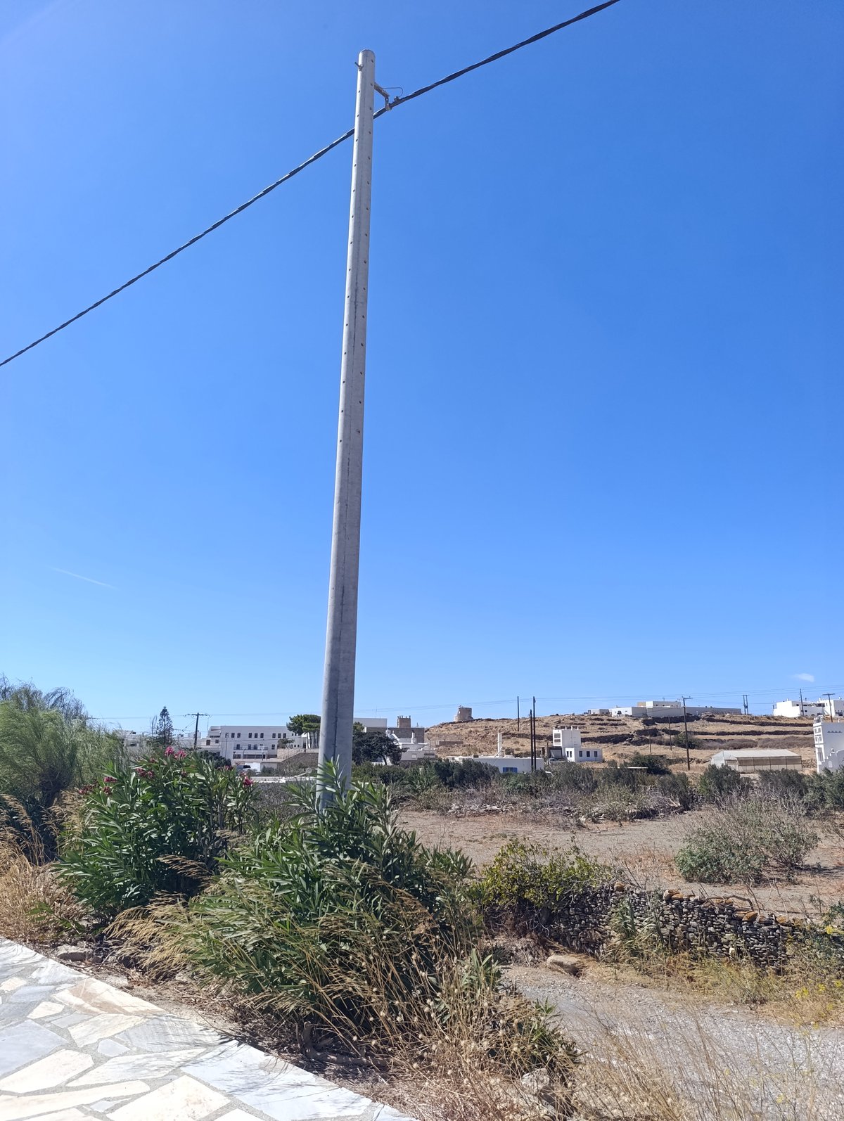 Τσιμεντένια κολόνα του δικτύου στην άκρη χωραφιού κοντά στη Χώρα της Τήνου