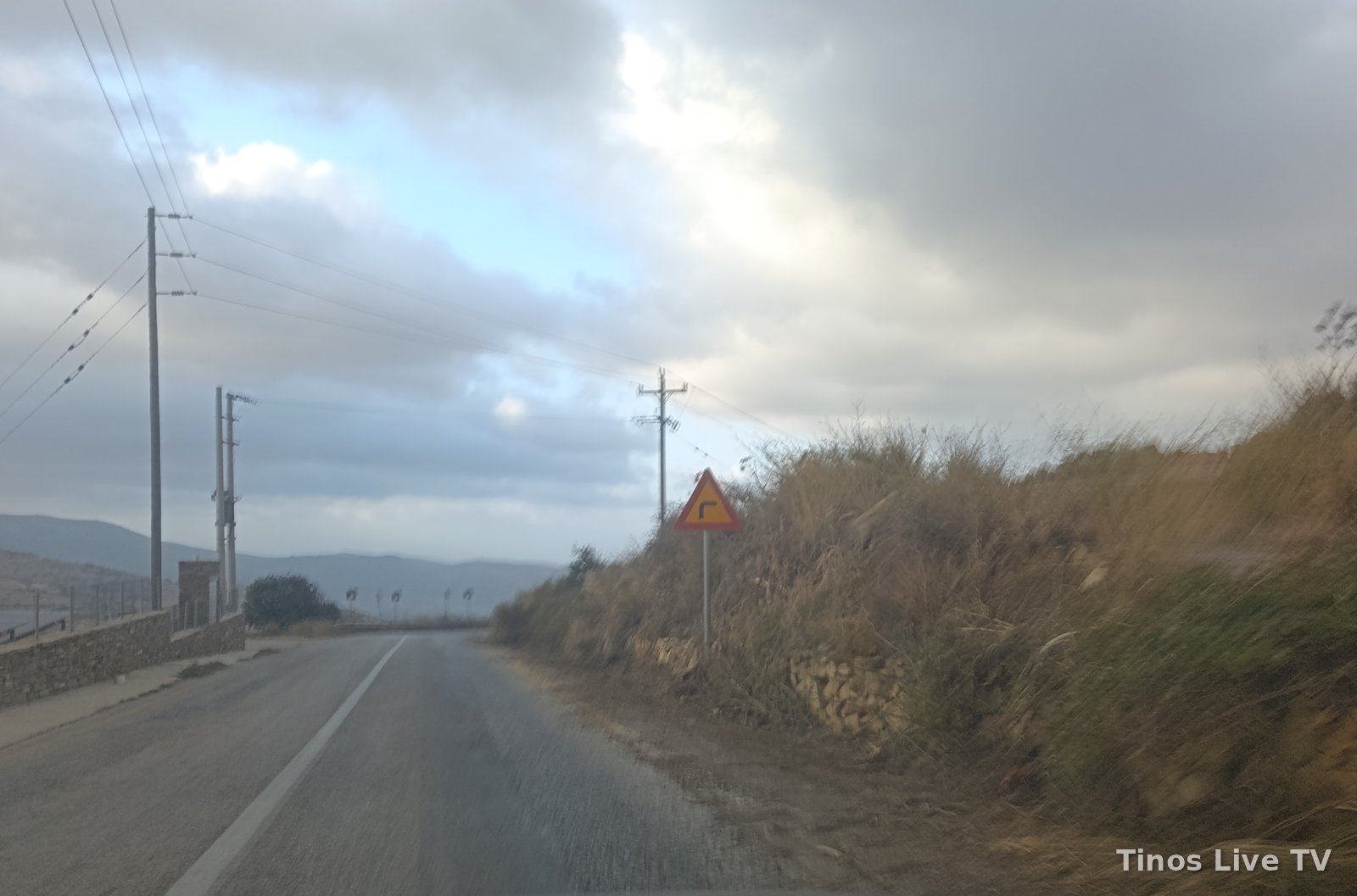 Πινακίδα επικίνδυνης στροφής και έρεισμα με χώμα και ξερά χόρτα στον δρόμο Ξυνάρας – Λουτρών