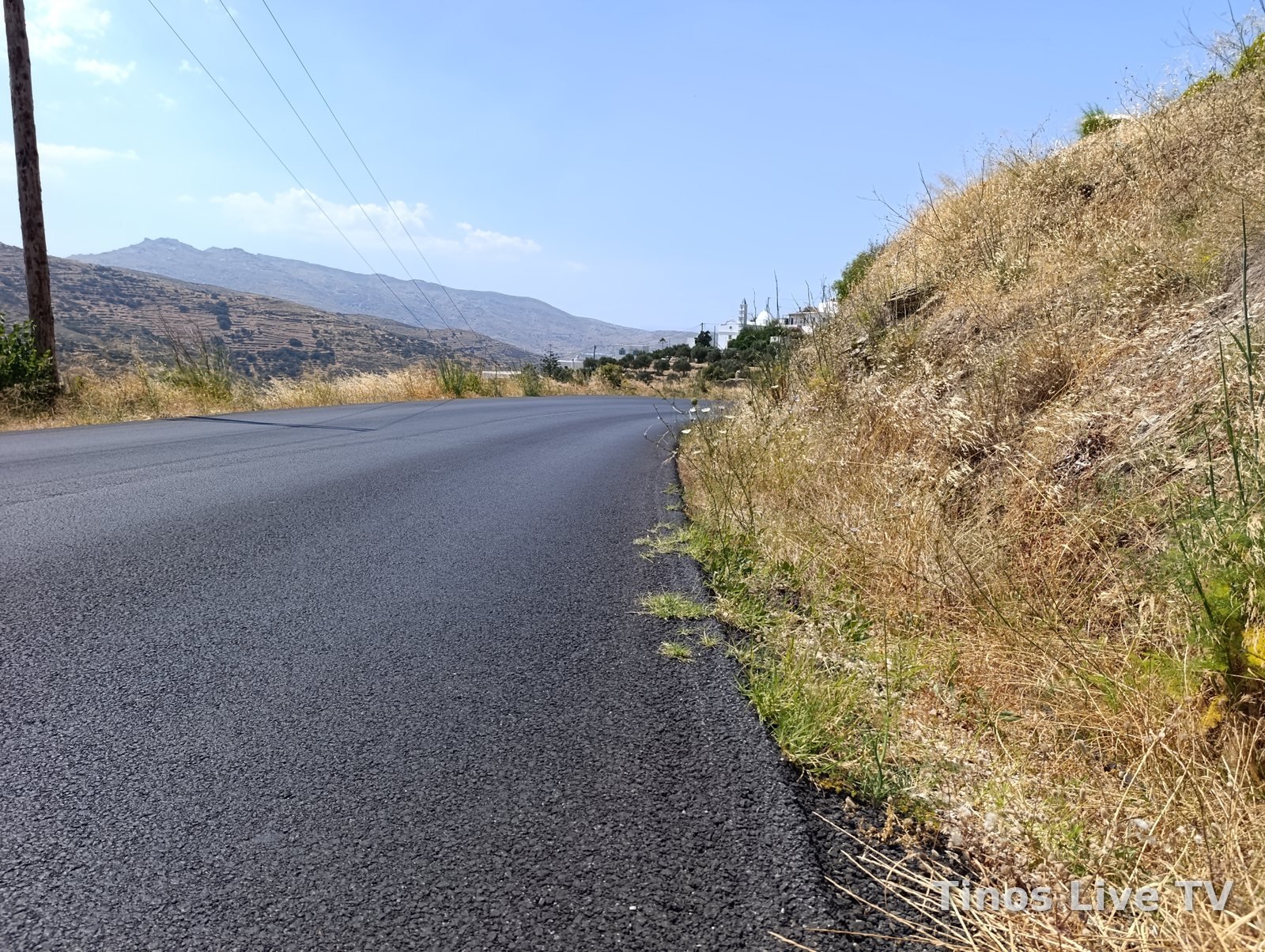 Η καινούργια άσφαλτος από χαμηλά, με χόρτα στην άκρη του δρόμου