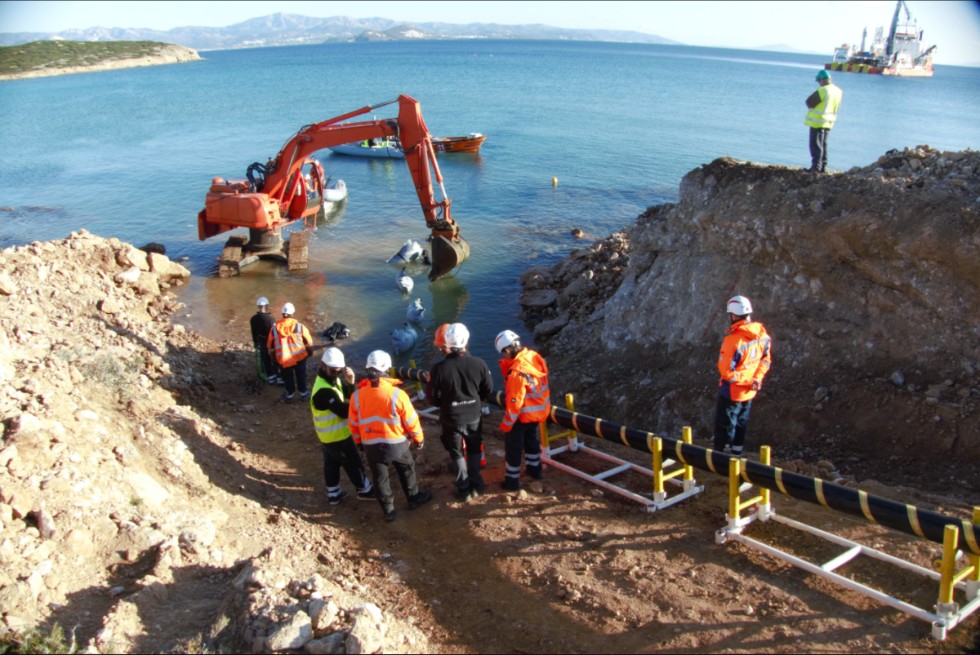 Συνεργεία στην προσγιάλωση υποβρύχιου καλωδίου, με το πλοίο πόντισης στο βάθος