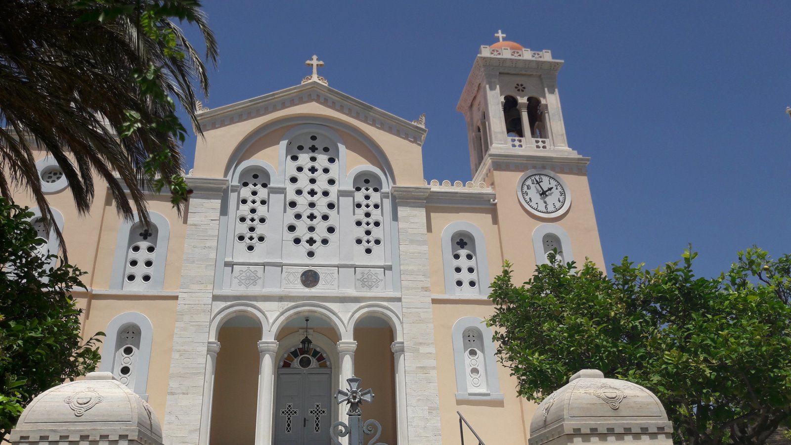 Η πρόσοψη του Ιερού Ναού Αγίου Δημητρίου Πύργου Τήνου, με το μαρμάρινο καμπαναριό και το ρολόι