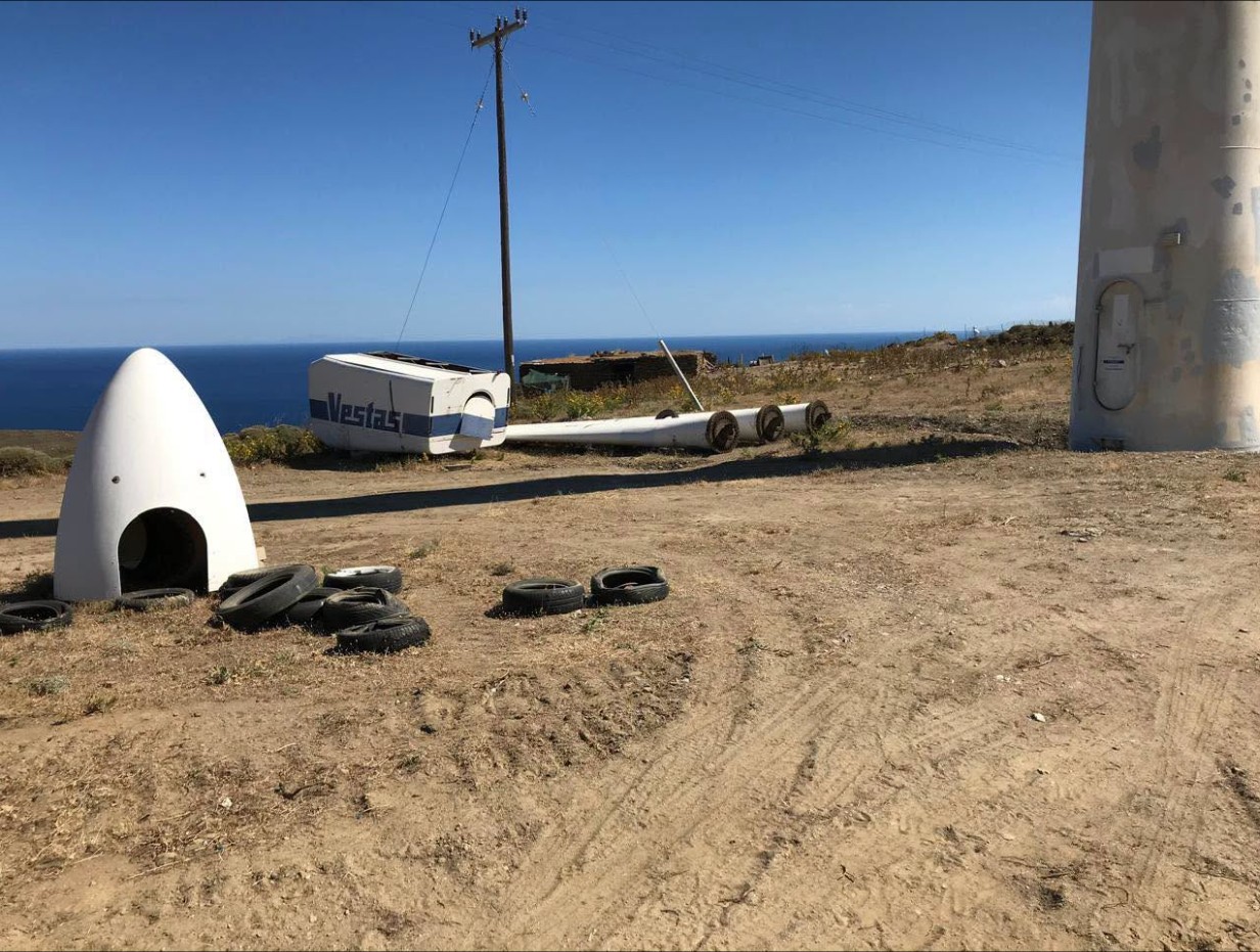 Κώνος ανεμογεννήτριας και παλιά λάστιχα στο χώμα, δίπλα σε πυλώνα ανεμογεννήτριας στο Καλιβάρι της Άνδρου