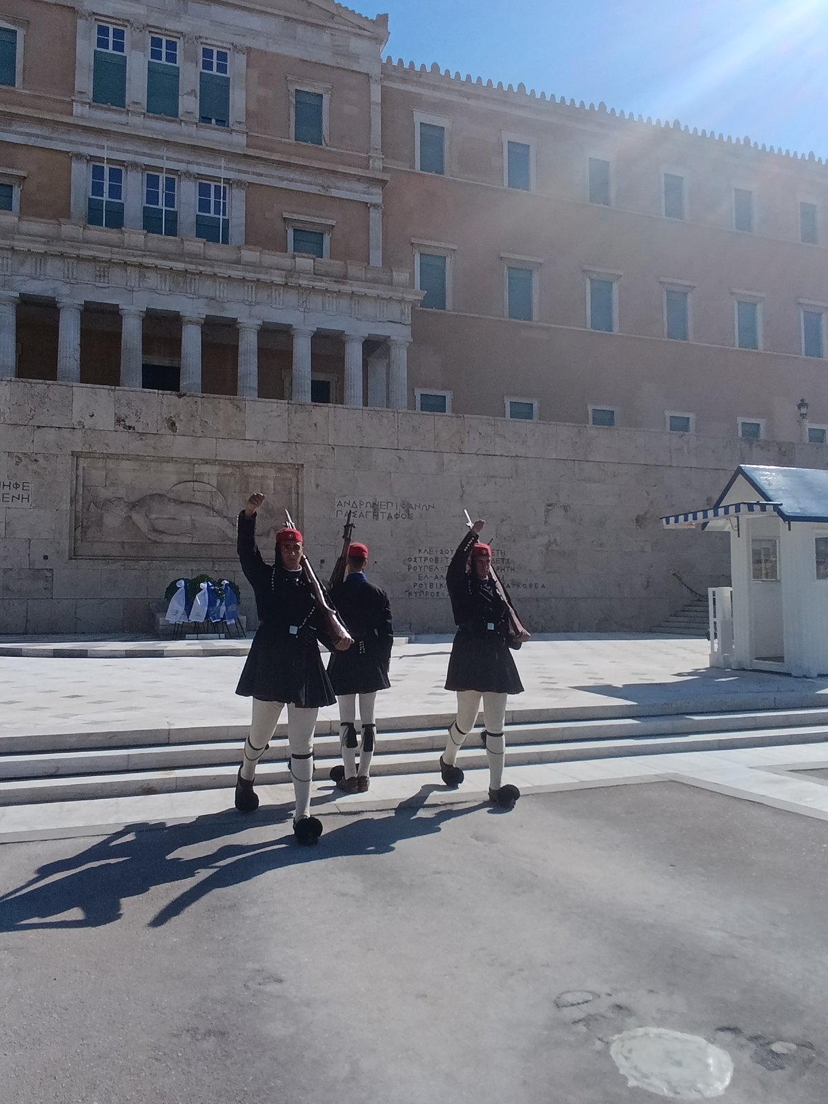 Δύο Εύζωνες με σηκωμένο το πόδι και το χέρι στην αλλαγή φρουράς μπροστά στη Βουλή