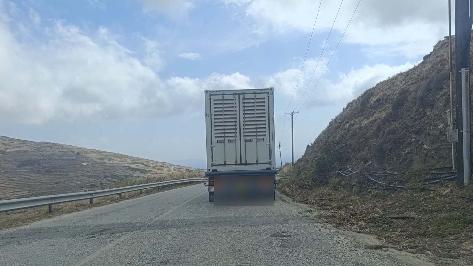 Φορτηγό μεταφέρει κοντέινερ-ηλεκτροπαραγωγό ζεύγος στον επαρχιακό δρόμο της Τήνου, 1 Οκτωβρίου 2026
