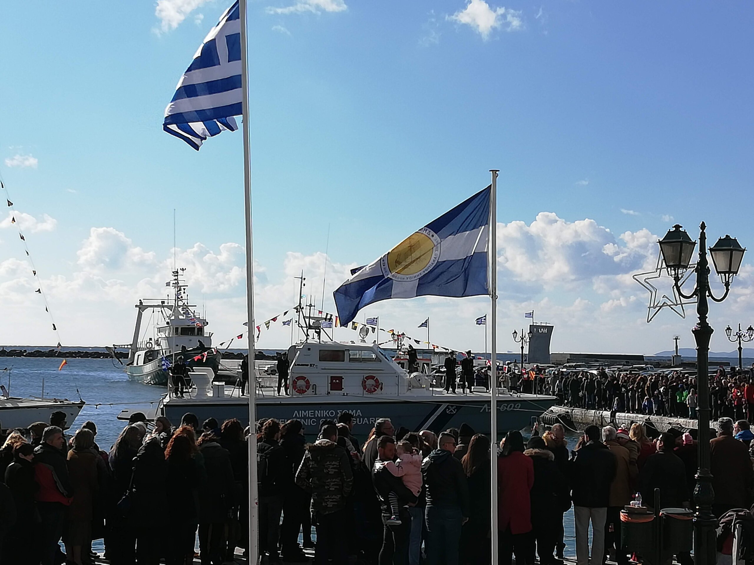 Γαλανόλευκες στο λιμάνι της Τήνου, με το μνημείο της «Έλλης» στο βάθος