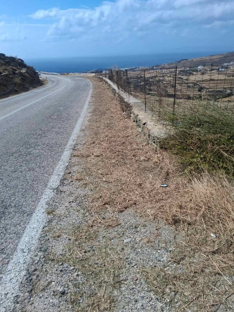 Καθαρισμένο έρεισμα με κομμένα ξερά χόρτα στην άκρη επαρχιακού δρόμου της Τήνου