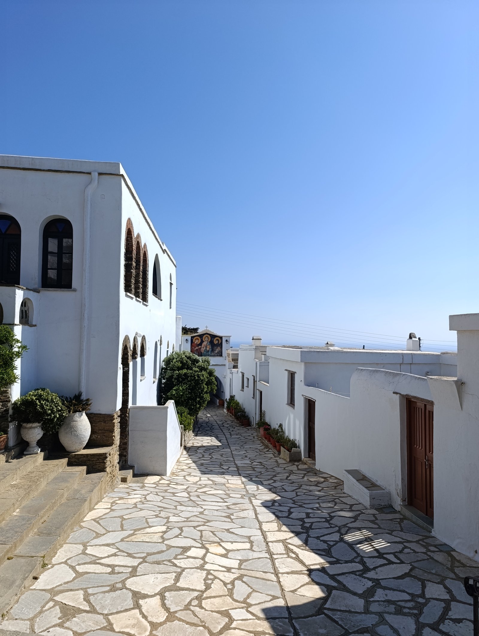 Το πλακόστρωτο ανάμεσα στα κελιά της Ιεράς Μονής Κεχροβουνίου, με το ψηφιδωτό στο βάθος και τη θάλασσα