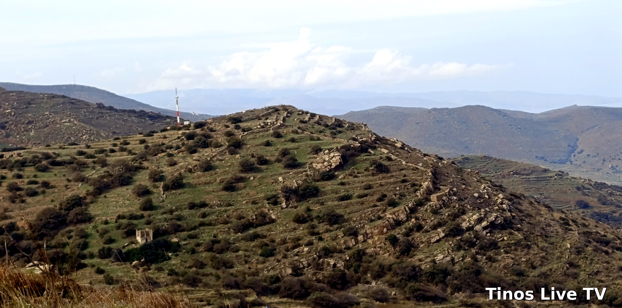Η νέα κεραία κινητής με κόκκινο-άσπρο ιστό στη ράχη κάτω από τον Κάμπο, από την πλευρά της Ξυνάρας